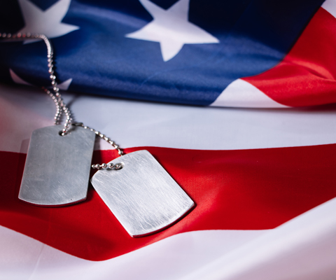 U.S. Flag with blank dog tags sitting on top - veteran concept